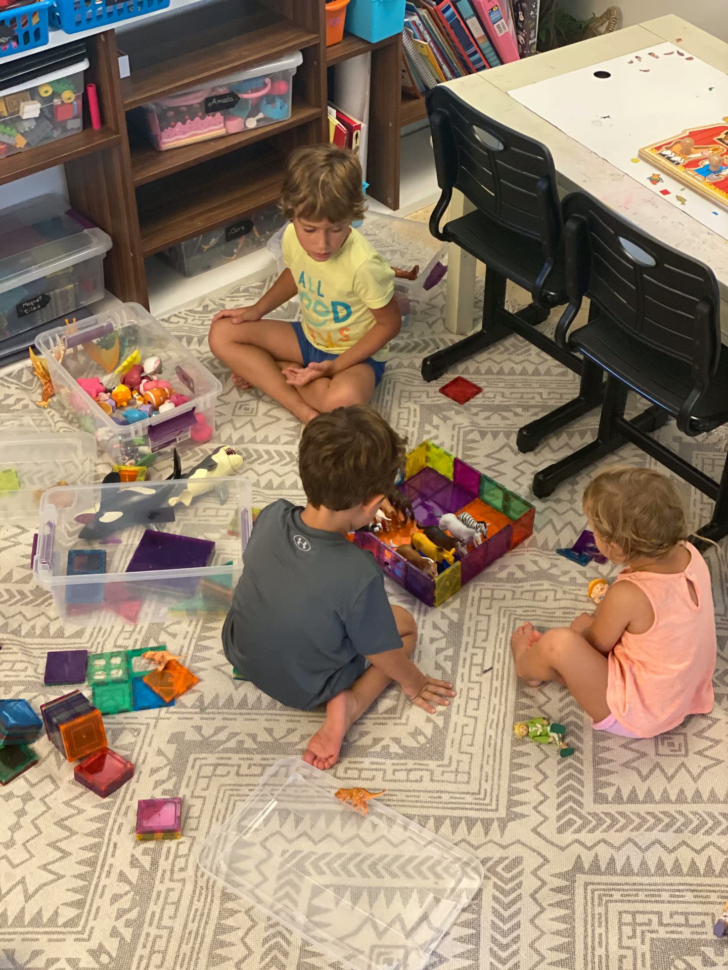 Children building with magnetic tiles on the floor